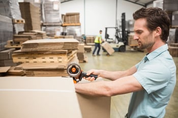 Man taping a packaged box